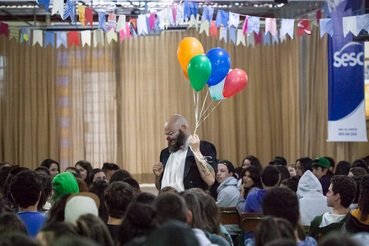 O ator James Beck em meio ao público durante o espetáculo clown É Tentando Que Se Desiste (Cia Carona de Teatro - Blumenau), na EEB Professor Honório Miranda (Gaspar)