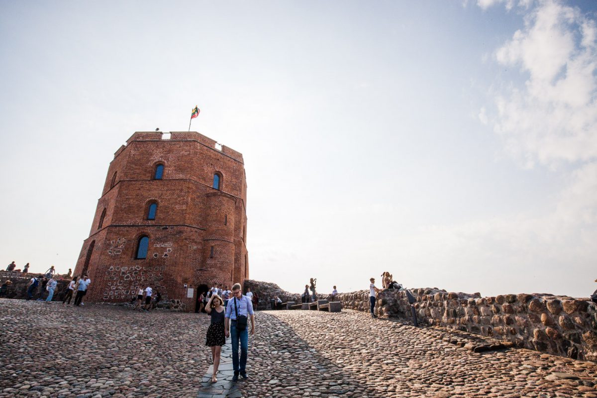 Casal caminha com outros turistas na Torre de Gediminas, local turístico em Vilnius, na Lituânia